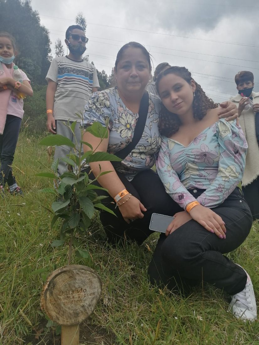 Madre e hija junto al árbol del médico Orlando Valencia Torres