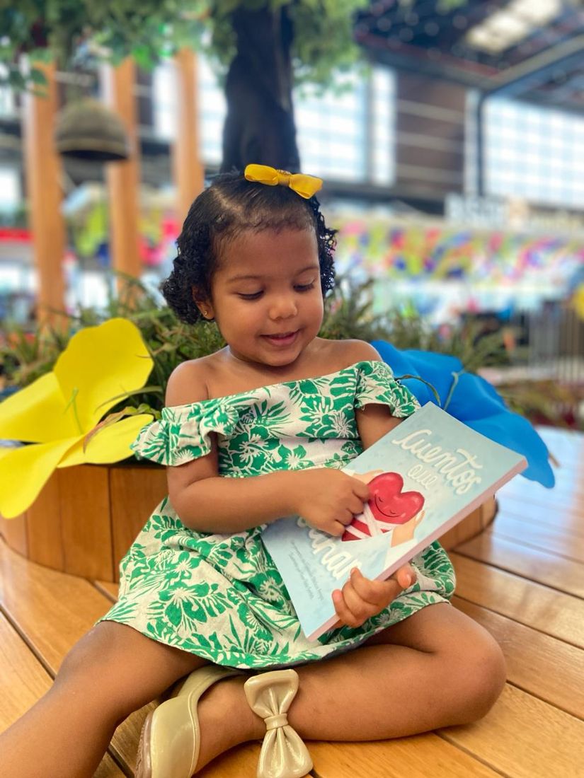 Niña hojea el libro Cuentos que Sanan