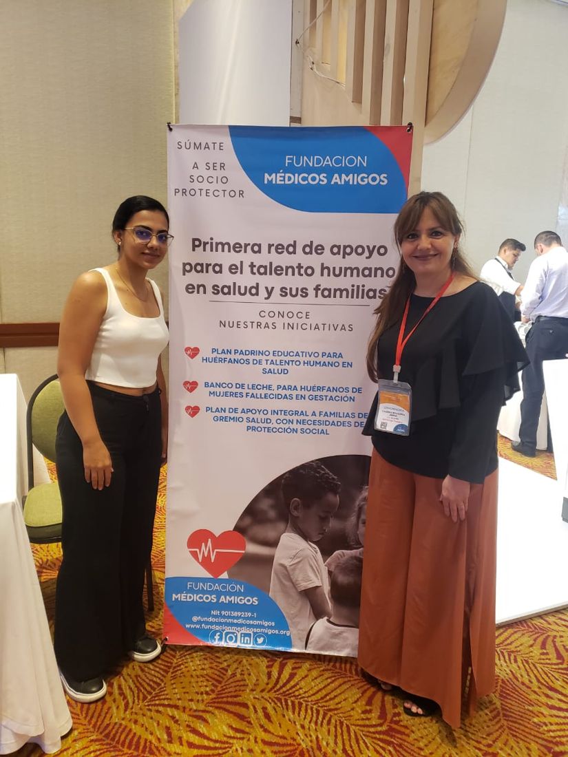Equipo de la fundación junto a su pendón en un congreso médico