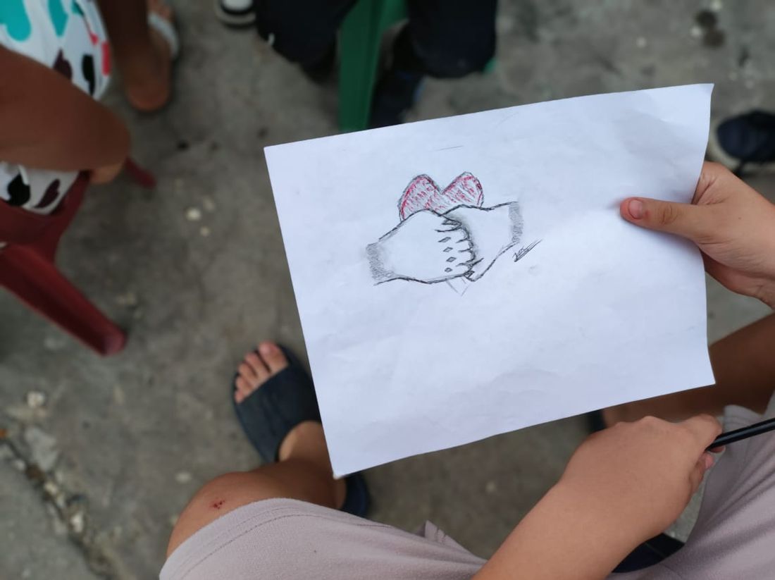 Dibujo de dos manos unidas frente a un corazón
